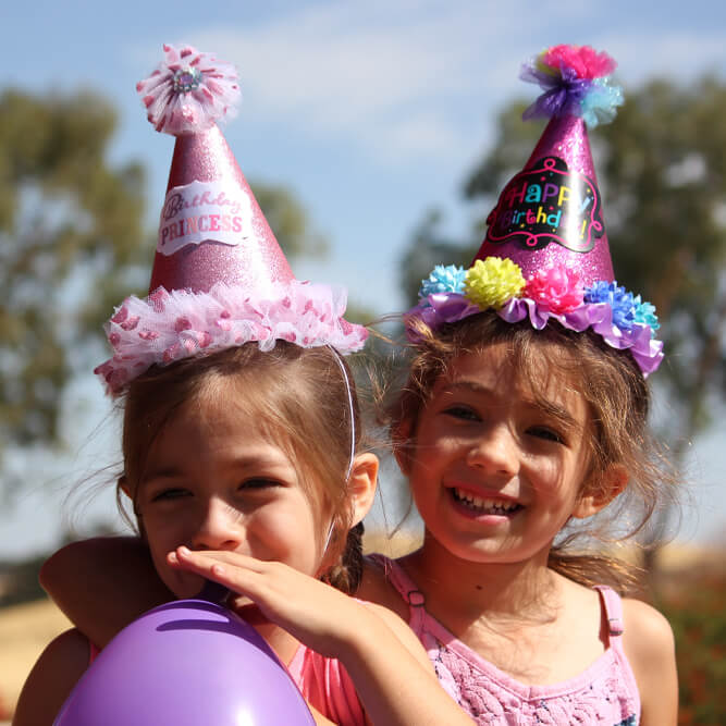 Two Young Girls With Party Hats On
